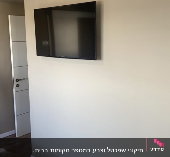 קיר צבוע בצבע בהיר עם טלוויזיה תלויה